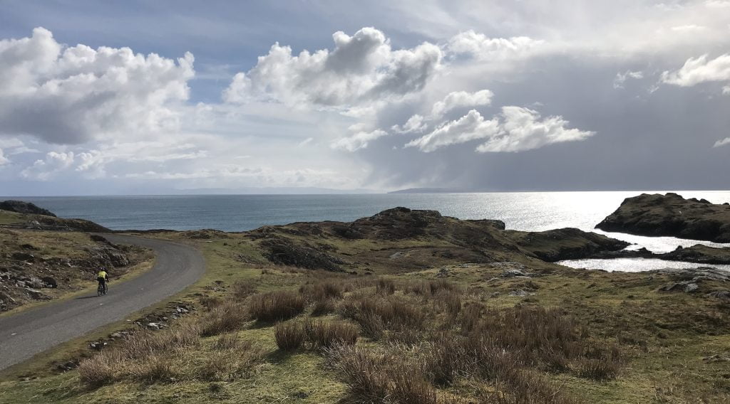 A cyclist rounds the headland about to cycle on the Golden Road The Hebridean Way NCN 780