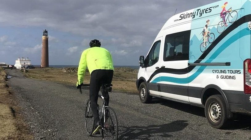 A cyclist arriving at the Butt of Lewis. They have ridden for 200 miles over 4 days supported by Skinny Tyres